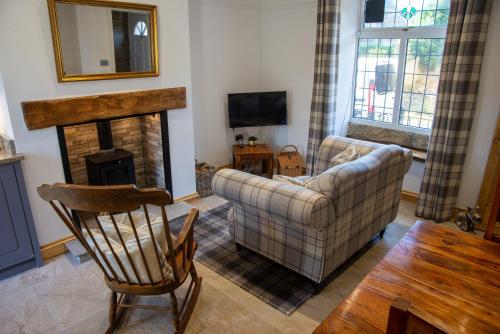 ein Wohnzimmer mit Couch und Kamin in der Unterkunft Steamy Cottage a cosy couples cottage & steam room in Haworth