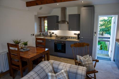 a kitchen with a table and a couch and a table and chairs at Steamy Cottage a cosy couples cottage & steam room in Haworth