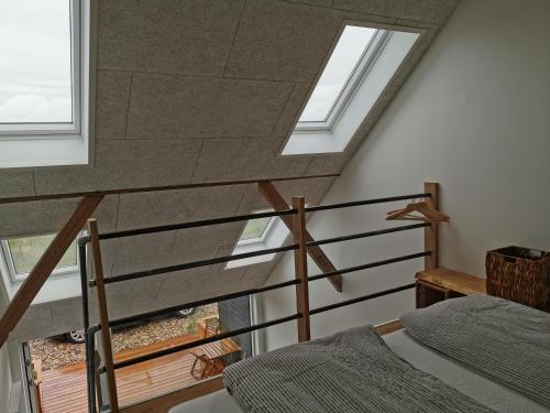 a room with a staircase with windows and a bed at Rikke og Franks Svineri in Lemvig