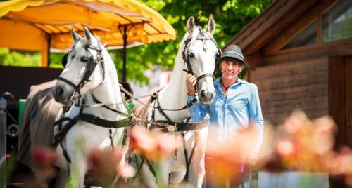 a man standing next to two white horses at LakeSide Apartments Seefeld in Seefeld in Tirol
