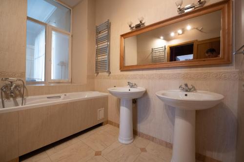 La salle de bains est pourvue d'un lavabo, d'une baignoire et d'un miroir. dans l'établissement Great 144 sq.m. apartment in the center of Kyiv, à Kiev
