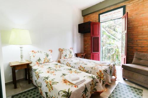 a small bedroom with a bed and a window at Casinha 2 suites in Tiradentes