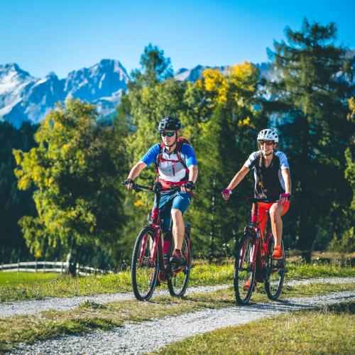 two people riding bikes down a dirt road at LakeSide Apartments Seefeld in Seefeld in Tirol