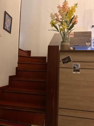 a staircase with a vase of flowers on a dresser at Hostel Casa Zambrano in Popayan
