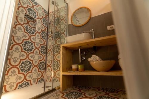 a bathroom with a shower with a sink and a mirror at La Casetta di Erasmina in Castellana Grotte