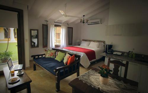 a bedroom with a bed and a couch and a table at La Casona Hotel Boutique in Asuncion