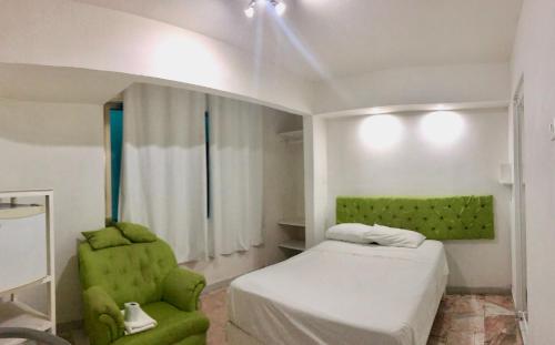 a bedroom with a green bed and a green chair at Zyan Rooms in Villahermosa