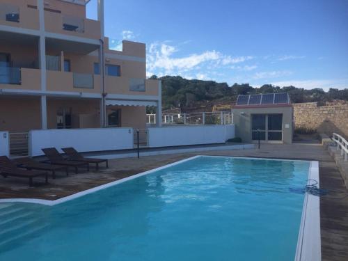 a large swimming pool in front of a building at Residence Le Terrazze in La Maddalena