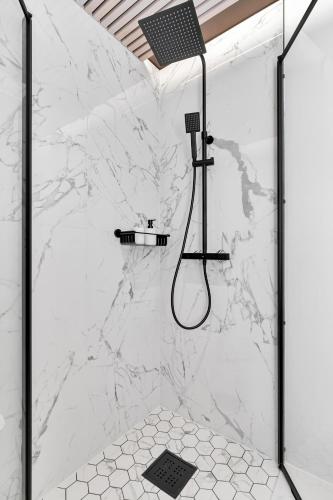 a bathroom with a shower with a white marble wall at In the heart of Narvik ! in Narvik