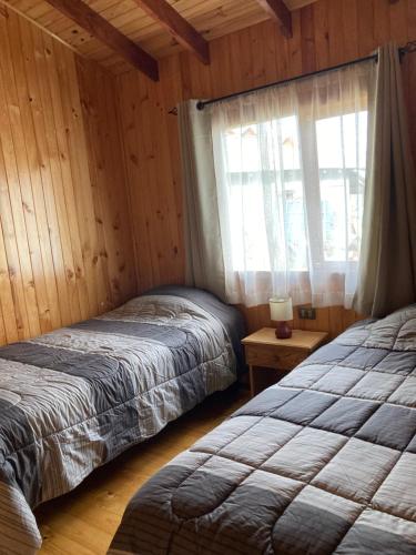 1 dormitorio con 2 camas y ventana. en Cabaña en Dalcahue, en Dalcahue