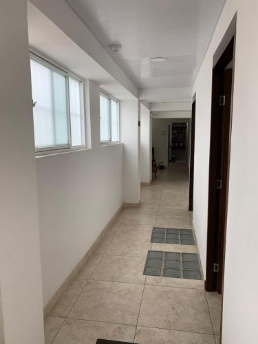 an empty hallway with white walls and windows at Hostel Casa Zambrano in Popayan
