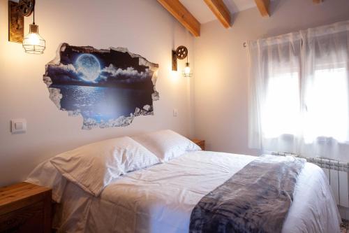 a bedroom with a bed with a painting on the wall at APARTAMENTOS LA VIEJA IMPRENTA in Sigüenza