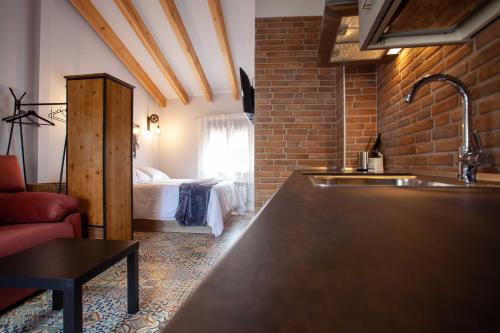 a kitchen with a sink and a bed in a room at APARTAMENTOS LA VIEJA IMPRENTA in Sigüenza