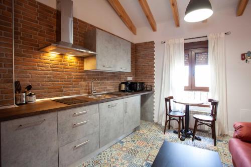 a kitchen with a counter and a table in a room at APARTAMENTOS LA VIEJA IMPRENTA in Sigüenza