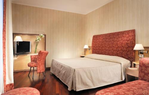 a hotel room with a bed and a tv at Poli Hotel in San Vittore Olona