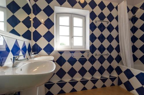 un bagno con pareti piastrellate blu e bianche e un lavandino di Château Pech-Celeyran a Salles-dʼAude