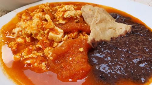 un plat blanc avec de la viande et de la sauce dans l'établissement Casa aroma de café, en el corazón de Coatepec., à Coatepec