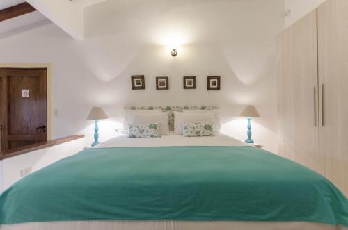 a bedroom with a large green bed with two lamps at La Casona Hotel Boutique in Asuncion