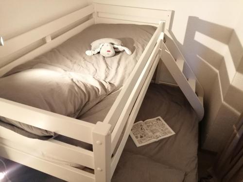 un berceau blanc avec un animal rembourré dans l'établissement Les Bergers Alpe d'Huez Pied des pistes et piscine, à Huez