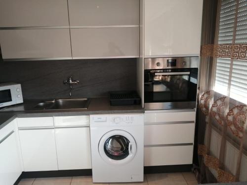 a kitchen with a washing machine and a sink at Location d'appartement entièrement meublé près de Genève in Annemasse