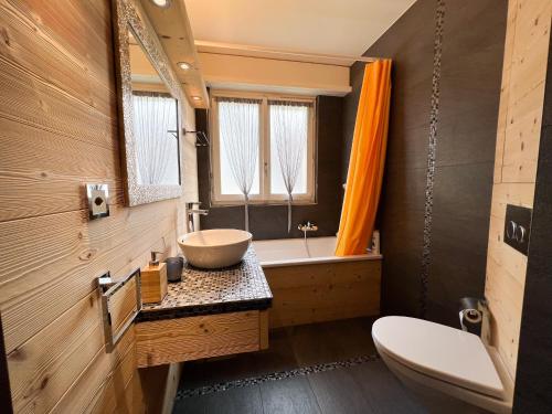 ein Badezimmer mit einem Waschbecken, einem WC und einer Badewanne in der Unterkunft Bel appartement 3 pièces au pied des pistes de ski in Crans-Montana