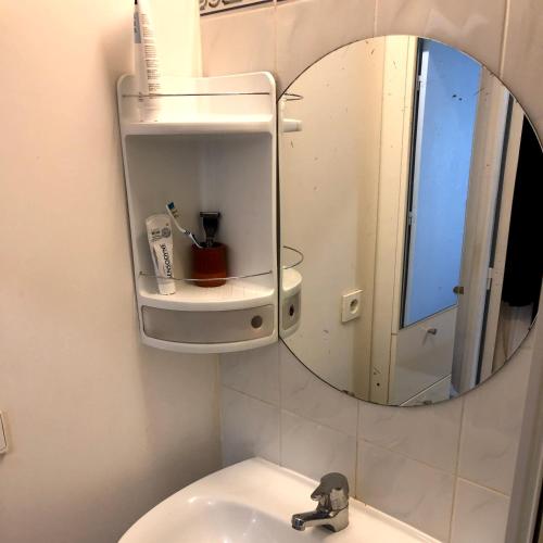 een badkamer met een spiegel en een wastafel bij 2 pièces à St Germain en Laye in Saint-Germain-en-Laye