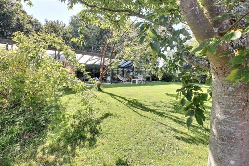 a yard with a tree and a house at gîte de la vache bleue en Somme in Bernaville