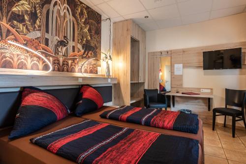 a hotel room with a bed and a desk at Land-Hotel Zum Schwan, Garni WEILERSWIST-METTERNICH in Weilerswist