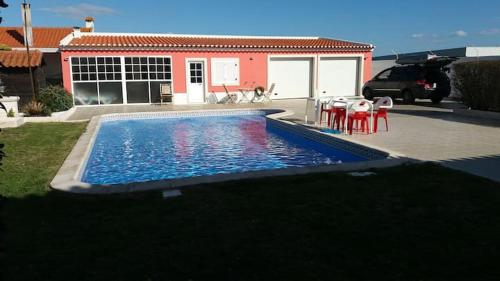 una casa y una piscina con mesa y sillas en Barrio Latino, en Samora Correia
