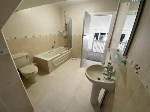a bathroom with a toilet and a sink and a tub at Broad Mead in Corfe Castle