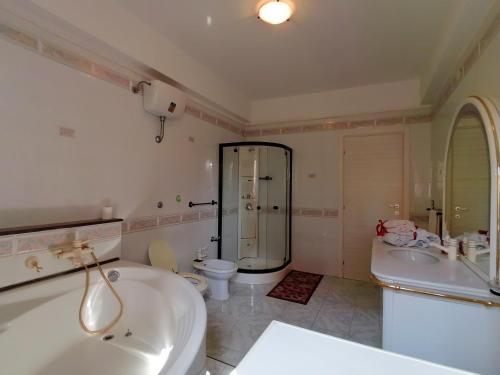 uma casa de banho com uma banheira, um chuveiro e um WC. em DA NONNA ROSA em Roccella Ionica