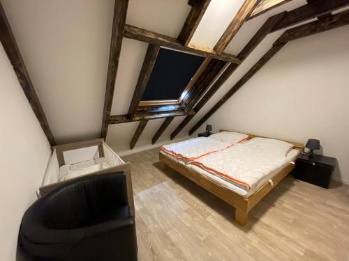 a attic bedroom with a bed and a chair at FeWoMik in Norden