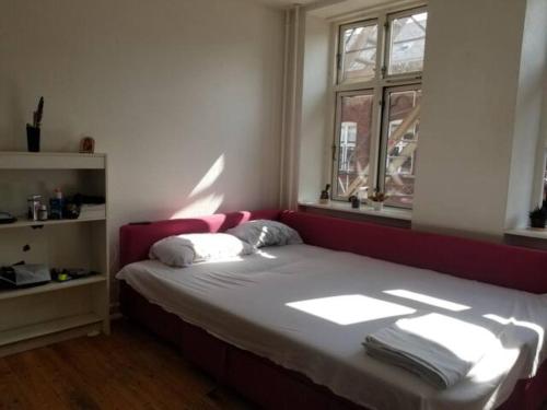 łóżko w pokoju z oknem w obiekcie Bright & Cozy Room in Zone 1 w Kopenhadze