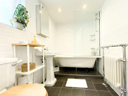 uma casa de banho com uma banheira e um lavatório em Pass the Keys Stockwell Apartment with a Private Garden em Londres