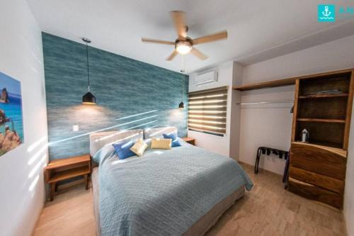 a bedroom with a bed with a painting of the ocean at Ancla Baja Living Condominio nuevo con vista 3 in La Paz