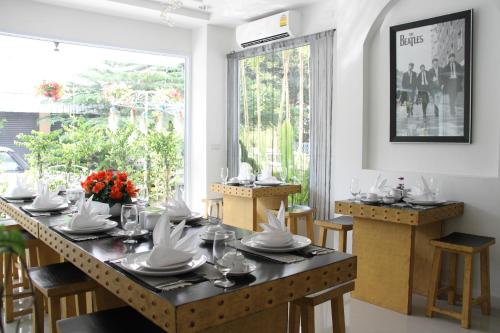 a dining room with a table with chairs and a large window at Jasmine Chiangmai Boutique Hotel in Chiang Mai