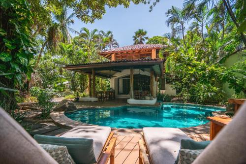 a house with a pool and a gazebo at Sueño del Mar Beachfront Hotel in Tamarindo