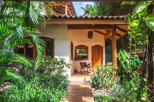 a house with a wooden pathway leading to the front door at Sueño del Mar Beachfront Hotel in Tamarindo