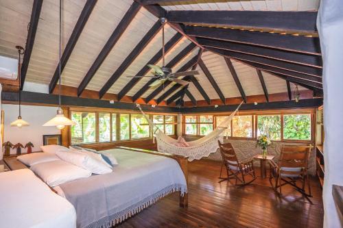 a bedroom with two beds and a hammock in it at Sueño del Mar Beachfront Hotel in Tamarindo