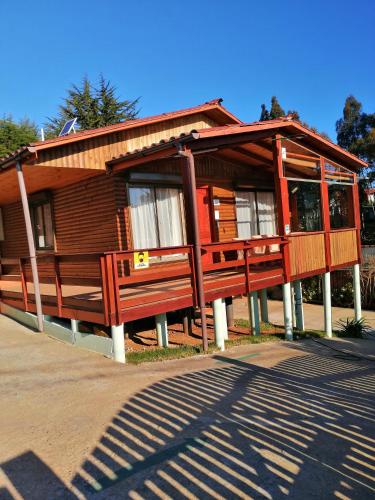 a wooden house with a bench in front of it at WilAnn SPA in Pichilemu