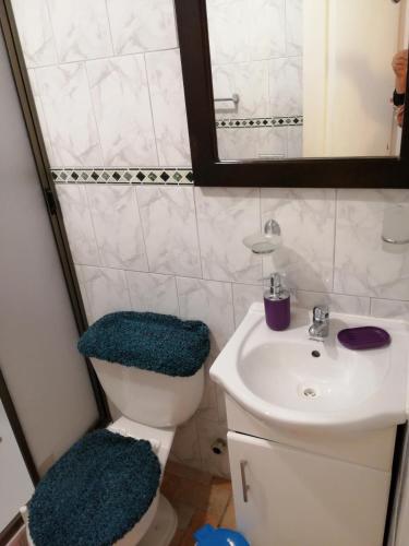 a bathroom with a sink and a toilet and a mirror at WilAnn SPA in Pichilemu