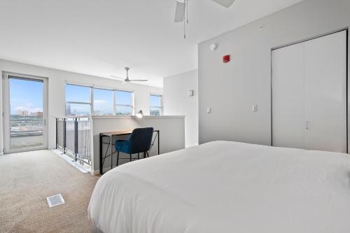 a white bedroom with a bed and a desk at Kasa South Side Pittsburgh in Pittsburgh