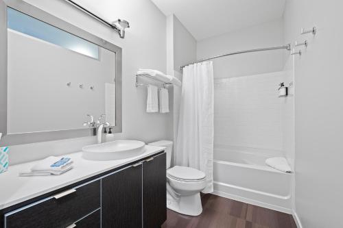 a white bathroom with a toilet and a sink at Kasa South Side Pittsburgh in Pittsburgh