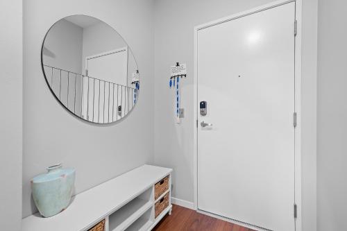 a white bathroom with a mirror and a sink at Kasa South Side Pittsburgh in Pittsburgh