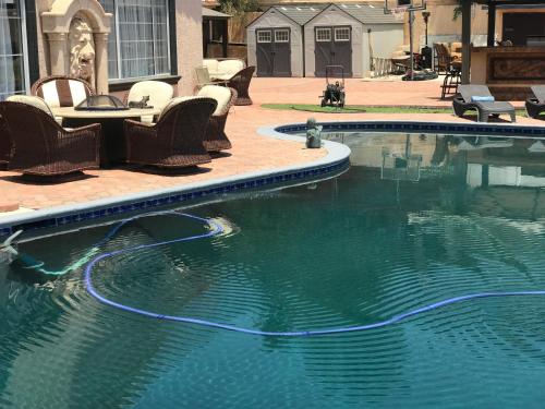 a swimming pool with chairs and a table next to it at paradise luxury experience in Woodland Hills