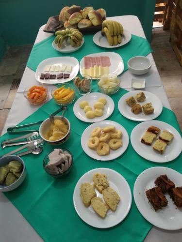 a green table with plates of food on it at Pousada Iguape in Iguape