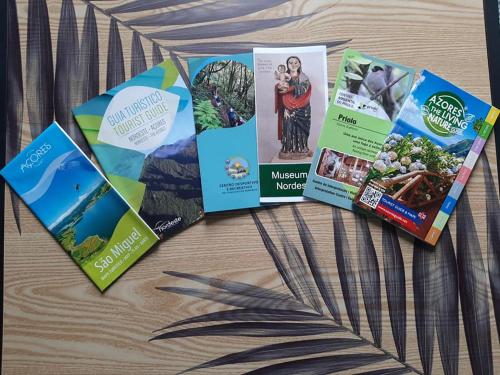 a group of brochures on a wooden table at Norverde - Açores in Nordestinho