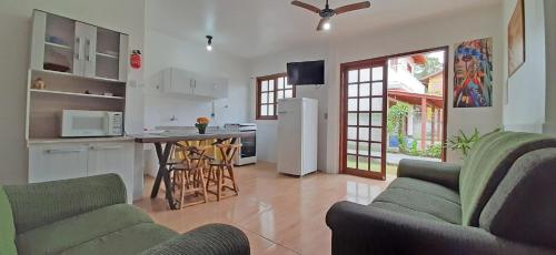 a living room with two couches and a kitchen at Recanto da Madre in Guarda do Embaú
