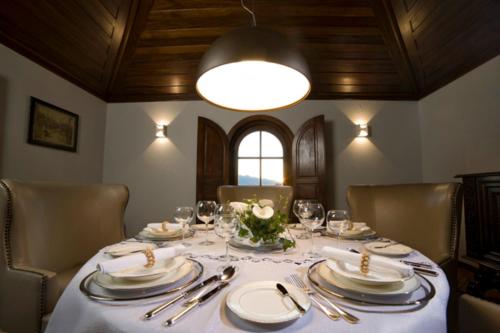 a dining room table with plates and silverware on it at Rinoterra Minho in Caminha