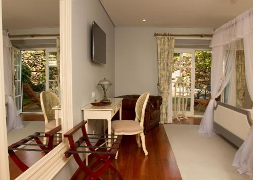 a living room with a desk and chairs and windows at Rinoterra Minho in Caminha